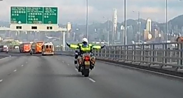 Traffic policeman leaves driving wheel with both hands and crosses a double white line in the tunnel