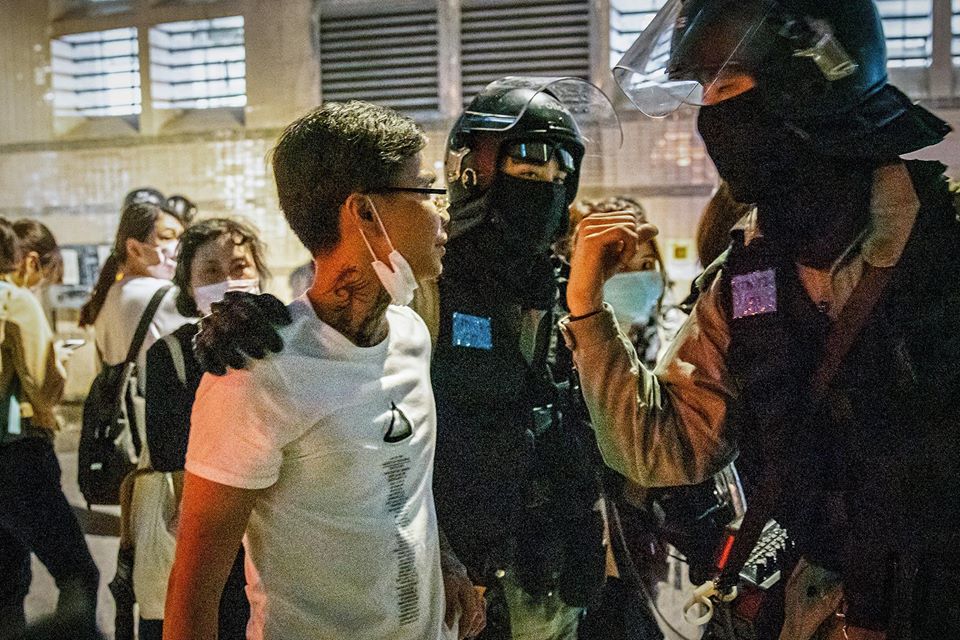 After tattooed man provoked citizens and insulted the press, riot police tapped his shoulder and escorted him to leave