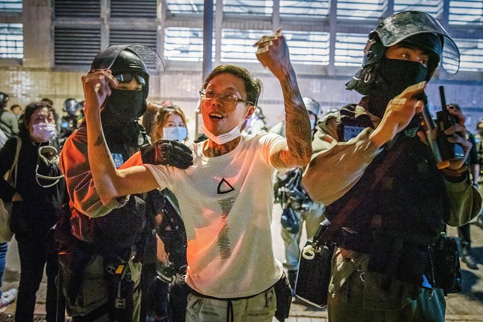 After tattooed man provoked citizens and insulted the press, riot police tapped his shoulder and escorted him to leave