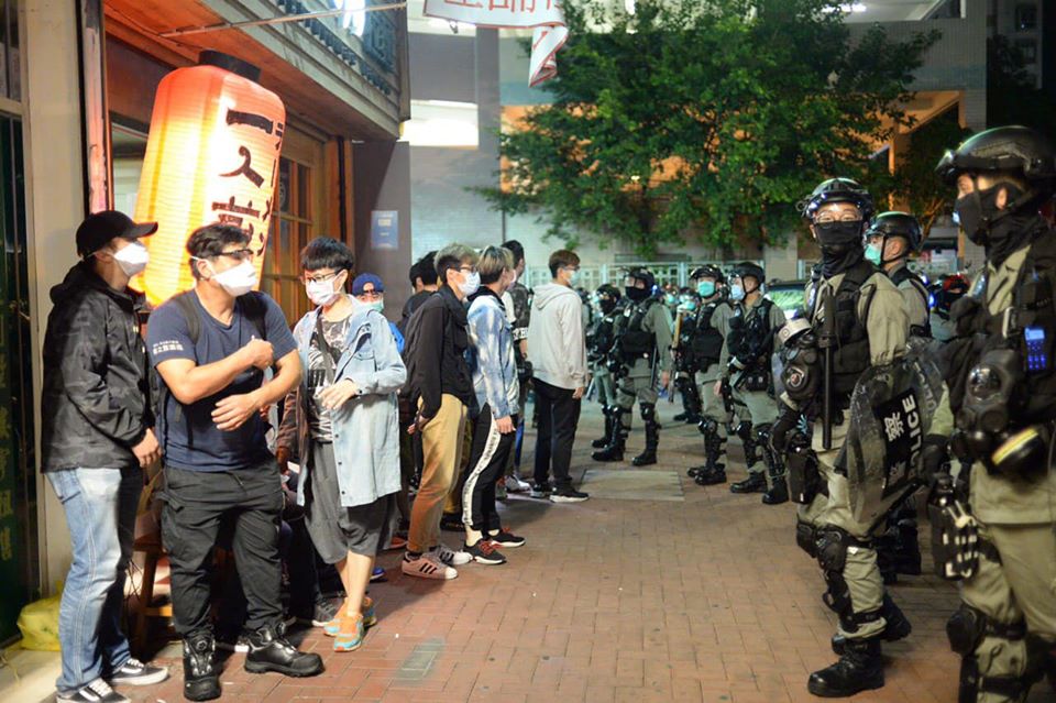 Riot police accuse people waiting outside restaurant of illegal assembly