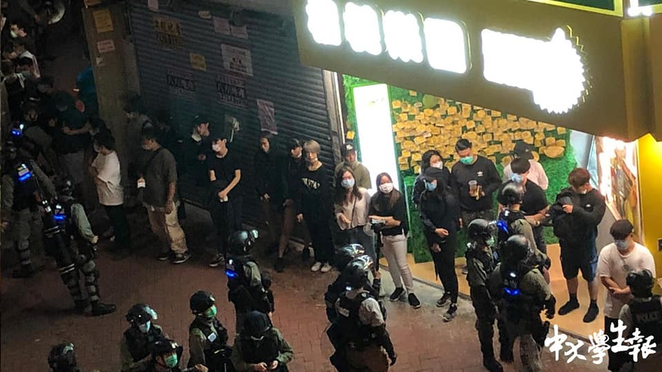 Riot police accuse people waiting outside restaurant of illegal assembly