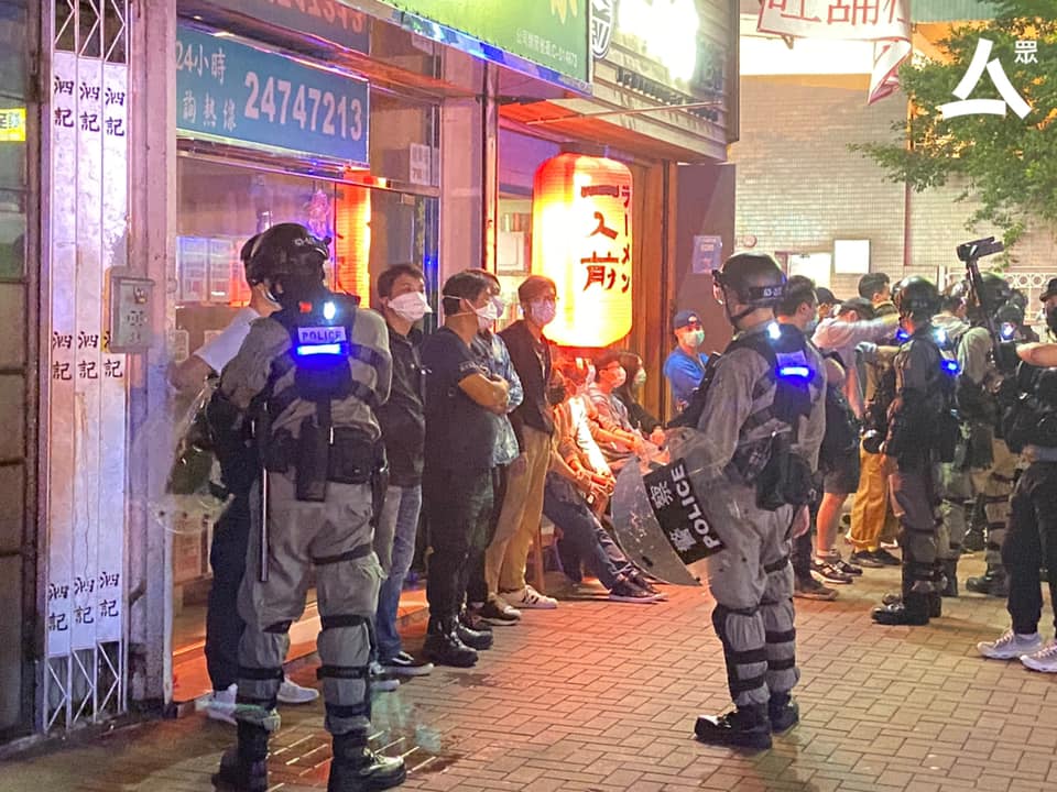 Riot police accuse people waiting outside restaurant of illegal assembly