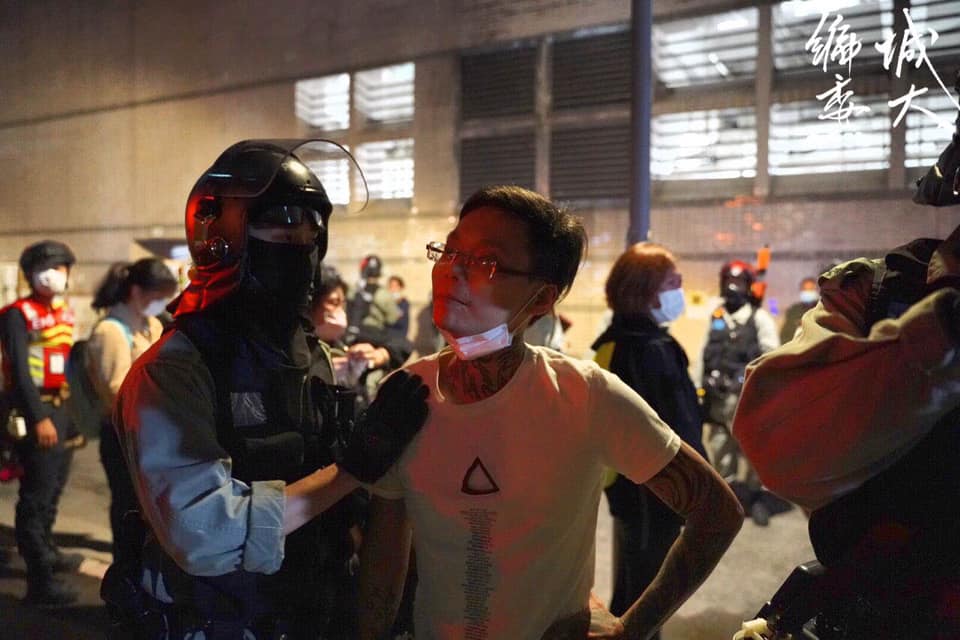 After tattooed man provoked citizens and insulted the press, riot police tapped his shoulder and escorted him to leave