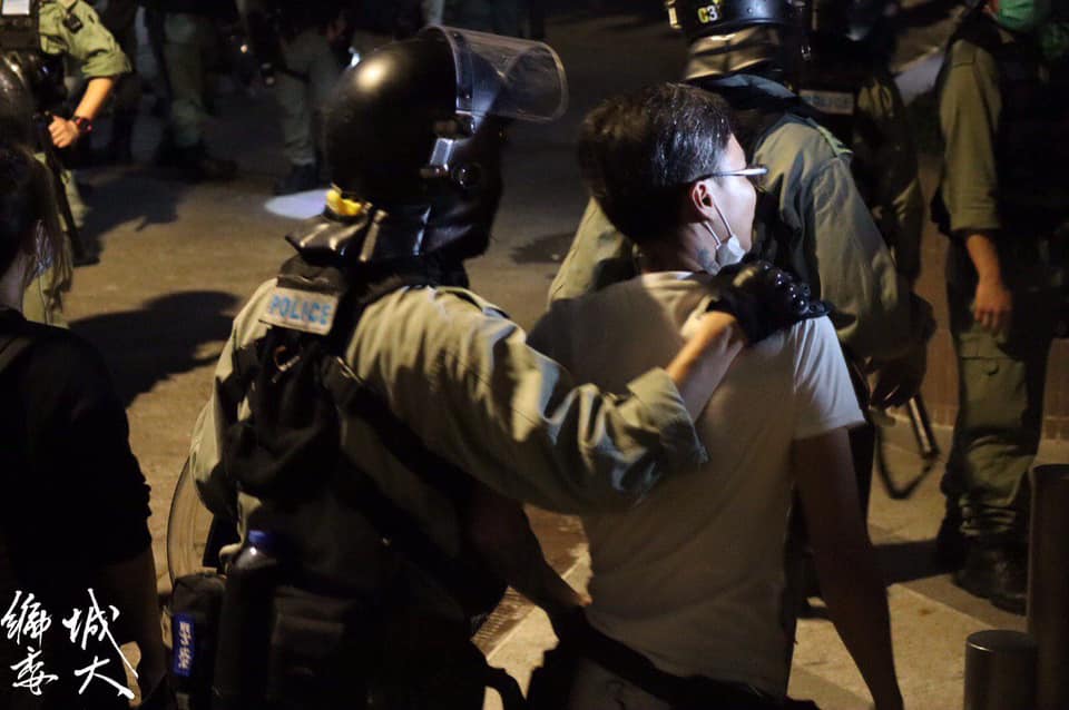 After tattooed man provoked citizens and insulted the press, riot police tapped his shoulder and escorted him to leave