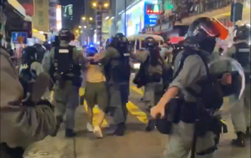 Dozens of police officers takes a man in a torture gesture, and the arrested youth suffers unnecessary pain