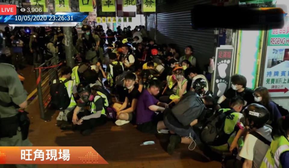Large number of reporters surrounded by riot police, who ordered them to kneel, and swept them with pepper spray. Photograph was forbidden.
